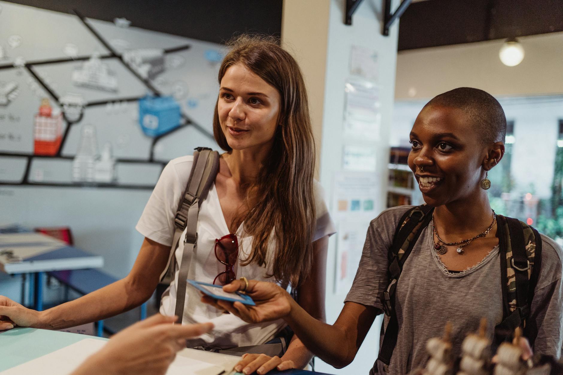Two women tourists engaging at a hostel reception, offering a friendly atmosphere.