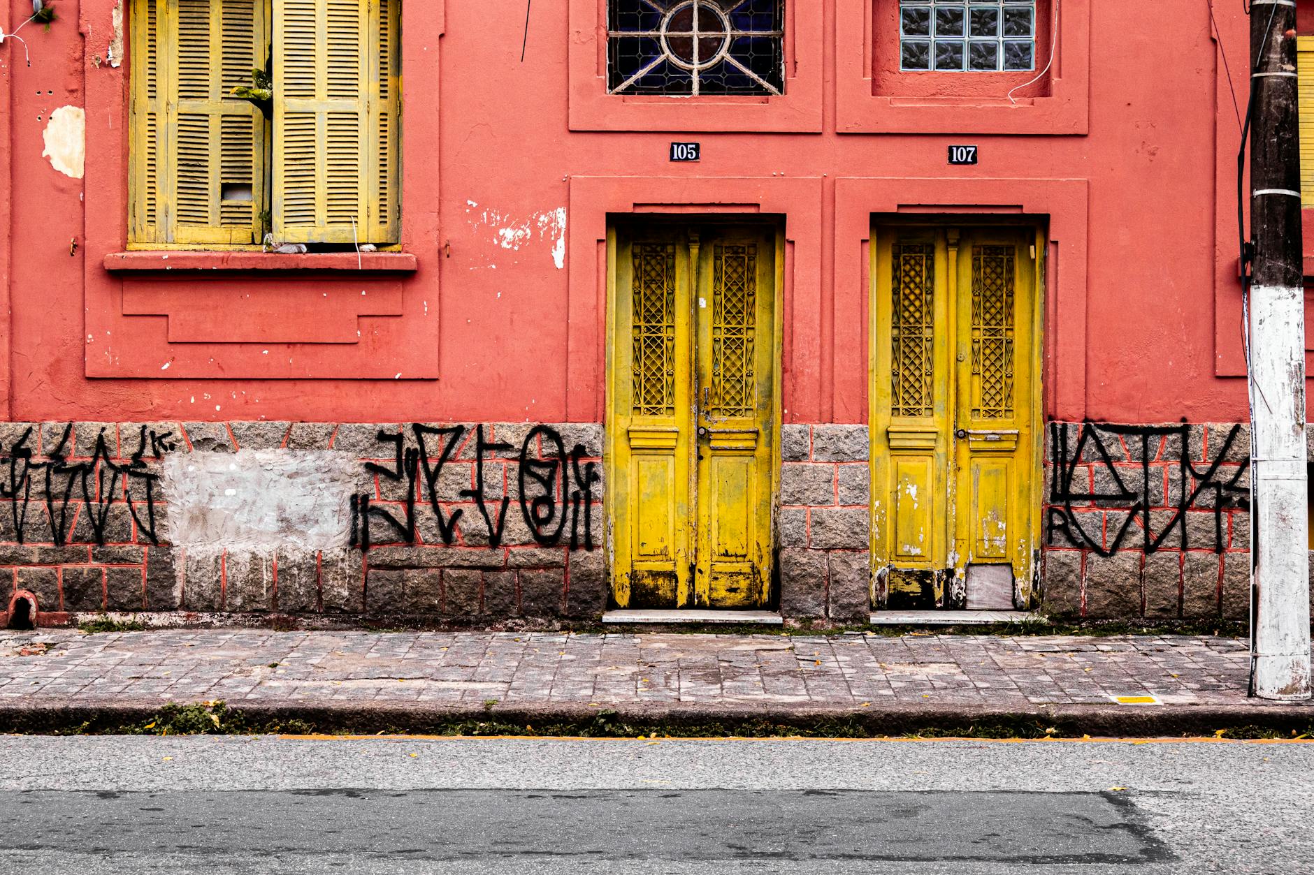 Graça Sem Pressa: Cafés, Miradouros E Ruas Bonitas 4 Vibrant building exterior with red walls, yellow doors, and expressive graffiti art.