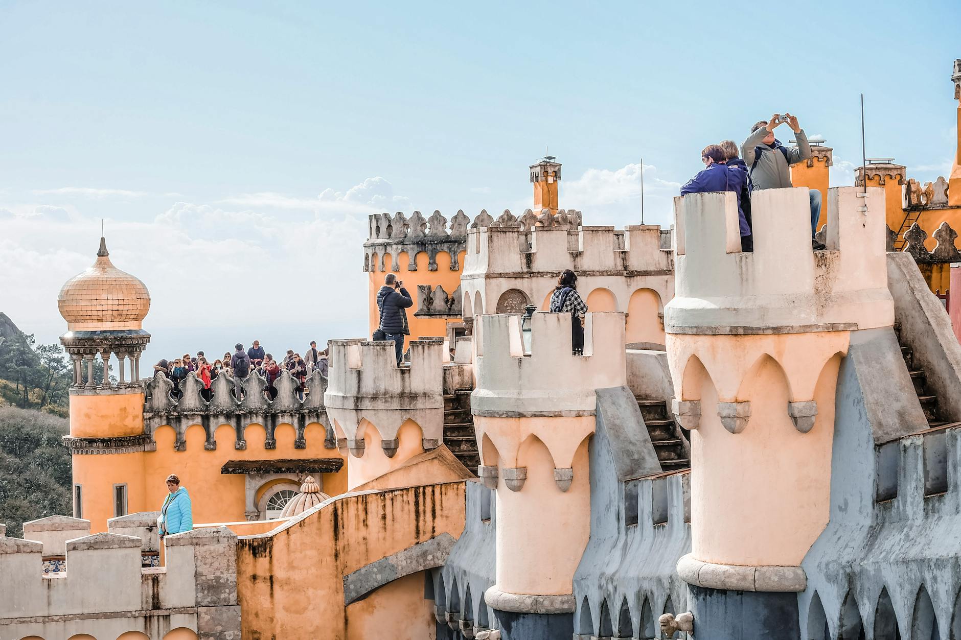 Vibrant view of tourists at the colorful Pena Palace, a UNESCO World Heritage site in Sintra, Portugal.