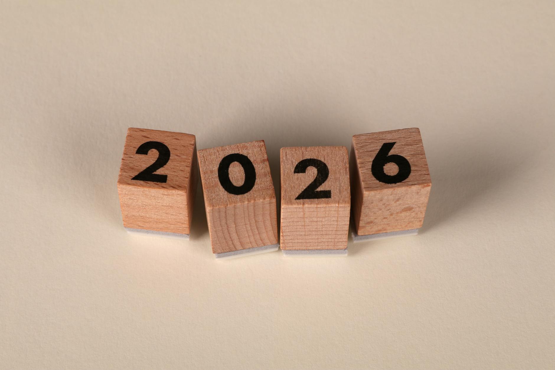 Comprar casa em 2026: como detectar “bairro do futuro” que é só conversa 7 Wooden cubes forming the year 2026 on a neutral background.